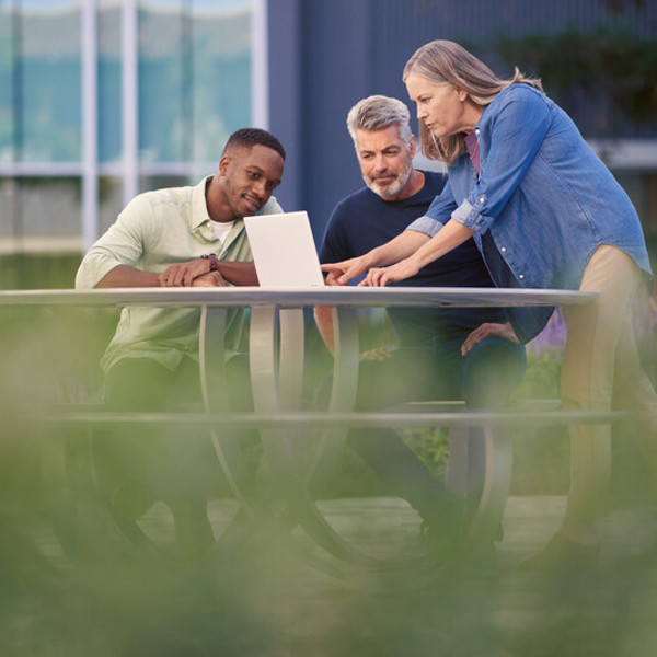 Employees collaborating together outside on table